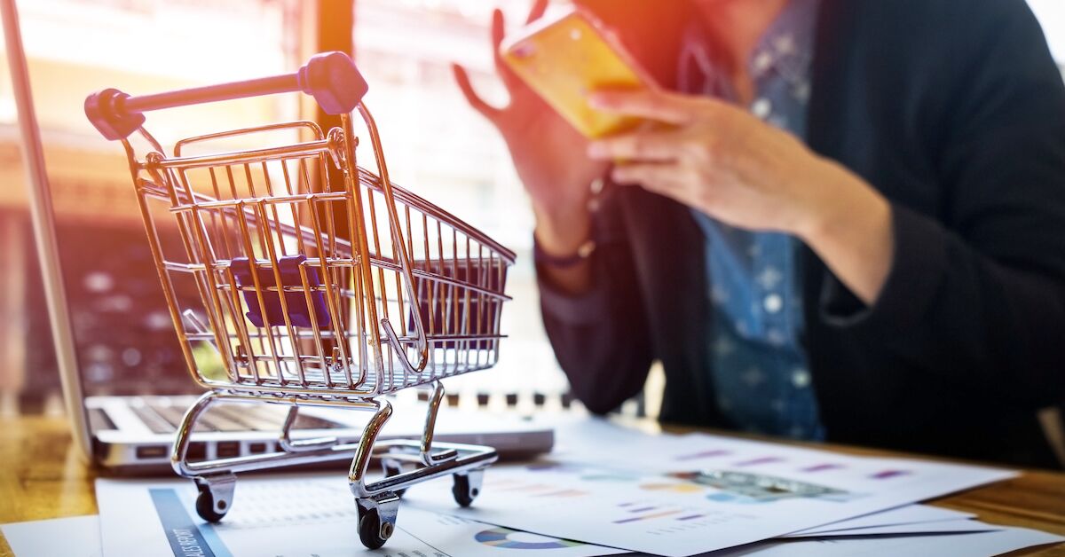Cropped image of woman inputting card information and key on phone or laptop while shopping online
